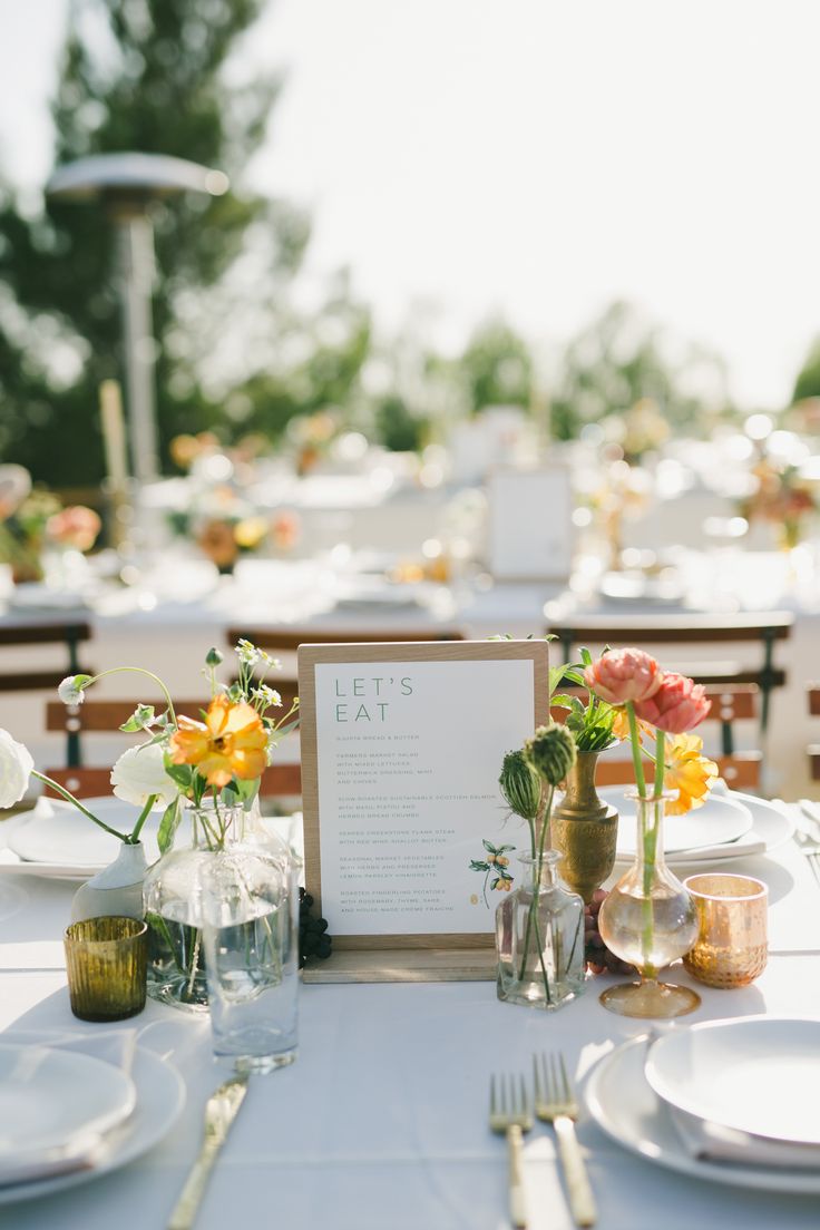 the table is set with flowers and place settings