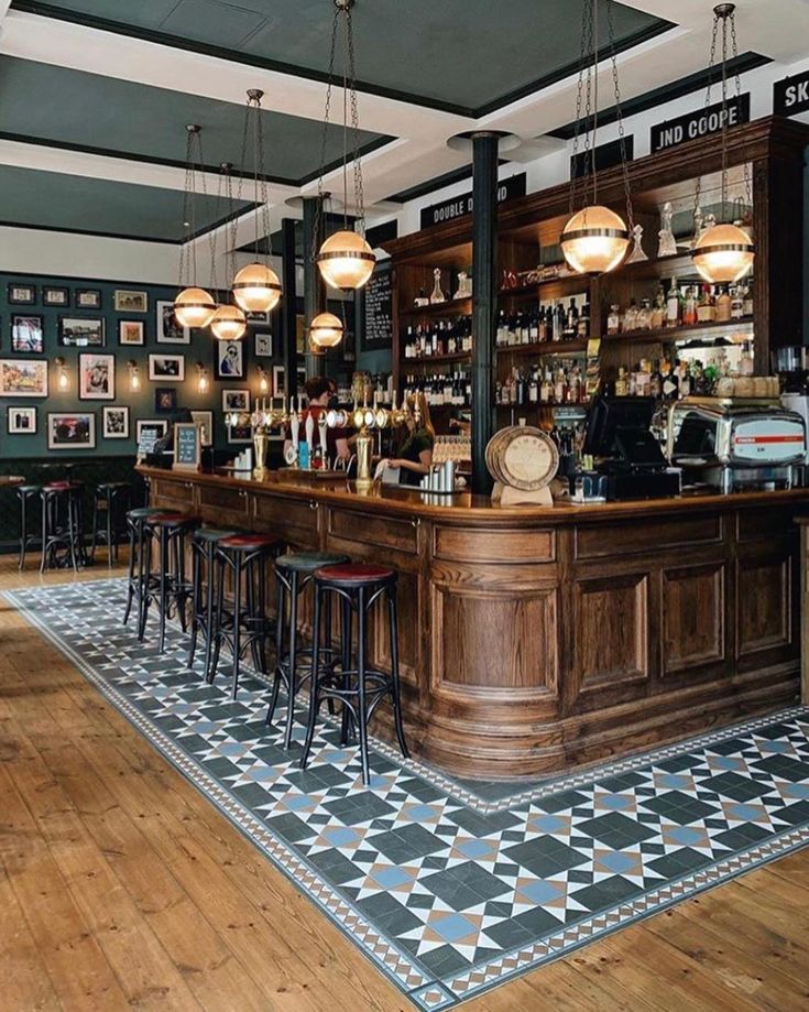 a bar with lots of stools and pictures on the wall