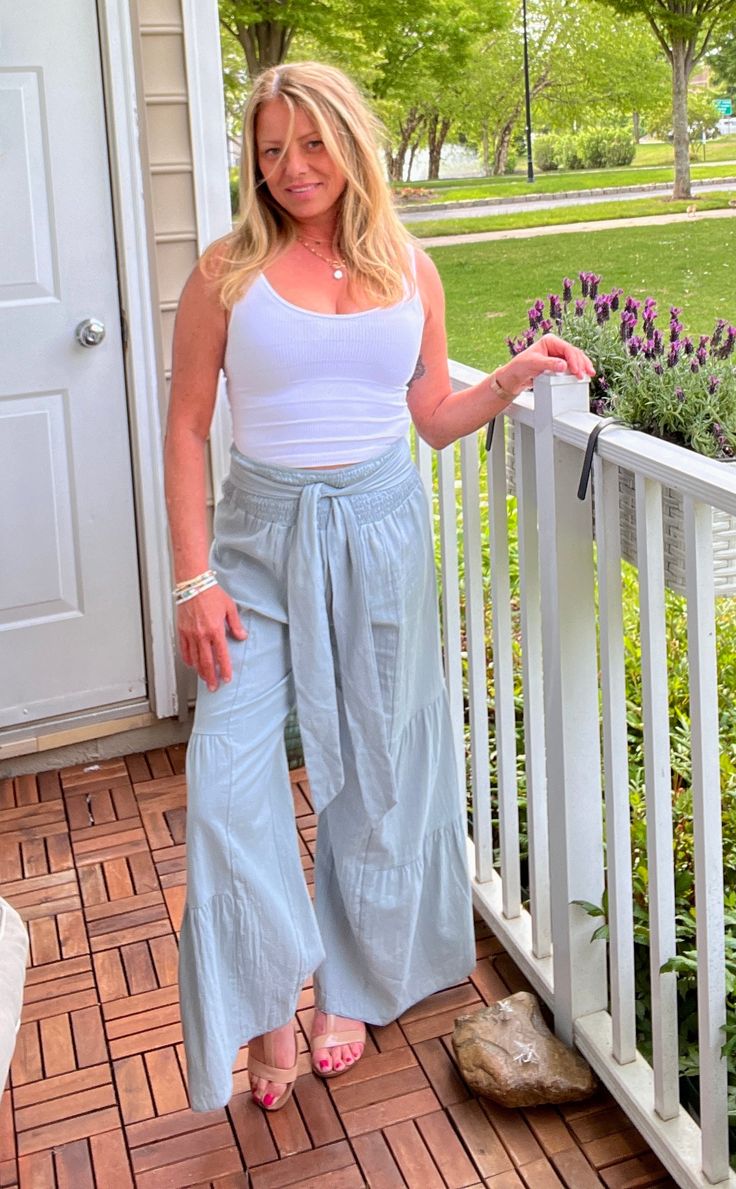 Exuding effortless style, these wide-leg pants feature a smocked waistband with tie detail, subtle tiers, and seams for added definition. 100% CottonThe run is a tad big. Due to the style, you can jump between sizes. Model 5'2",126lbs, wearing a small. Casual Flowy Ruffled Bottoms, Casual Flowy Bottoms With Ruffles, Flowy Ruffled Casual Bottoms, Chic Cotton Bottoms With Gathered Waist, Solid Bottoms With Tie Waist For Day Out, Relaxed Fit Pants With Gathered Waist For Spring, Casual Flowy Cotton Bottoms, Chic Bottoms With Gathered Waist For Spring, Casual Wide Leg Pants With Tie Waist