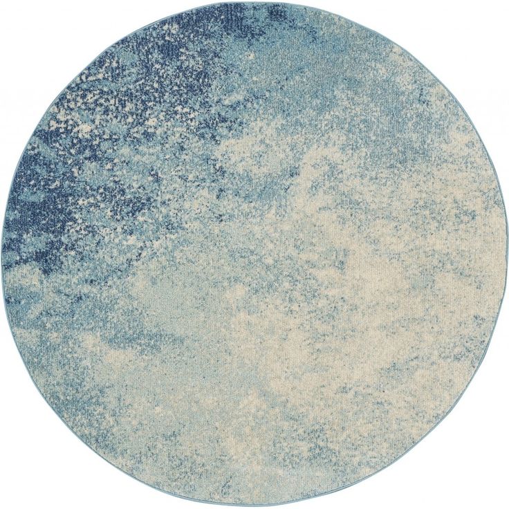 a round rug with blue and white paint on the top, in front of a white background