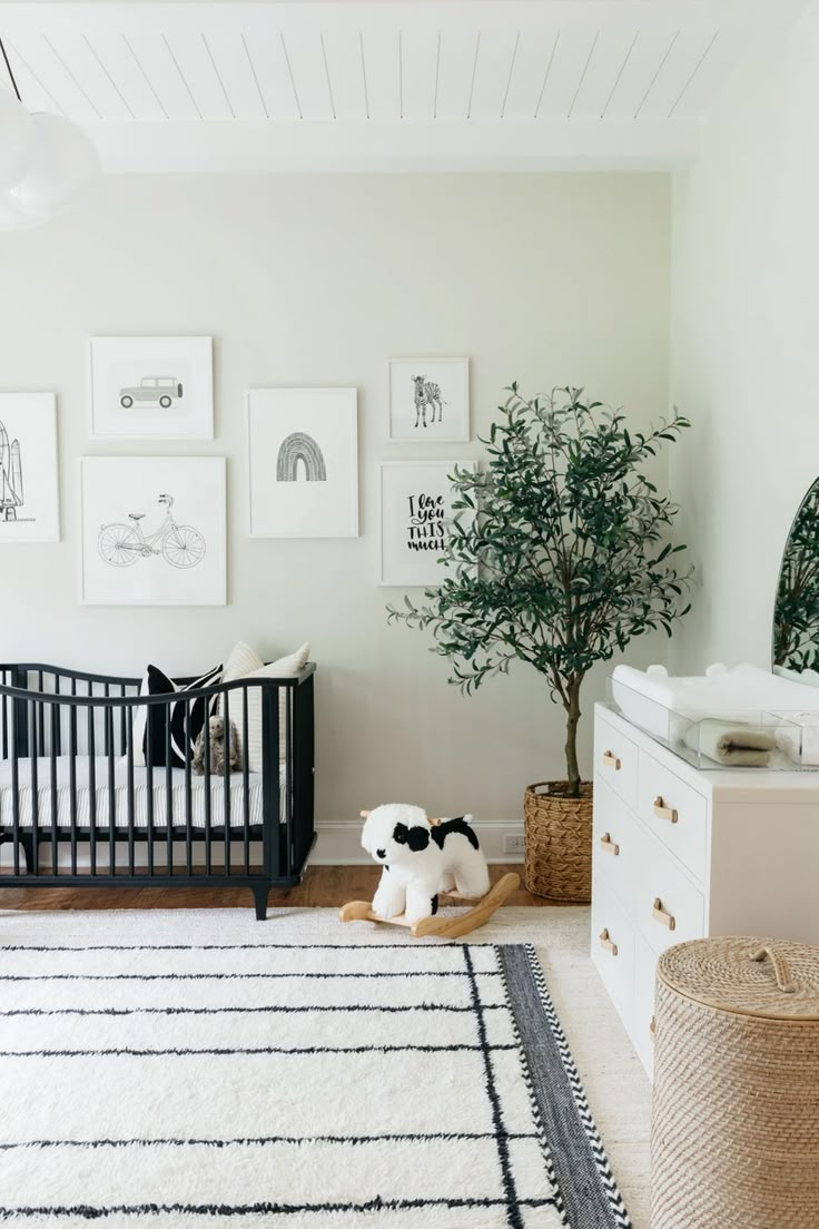 a baby's room with pictures on the wall and a crib in the foreground