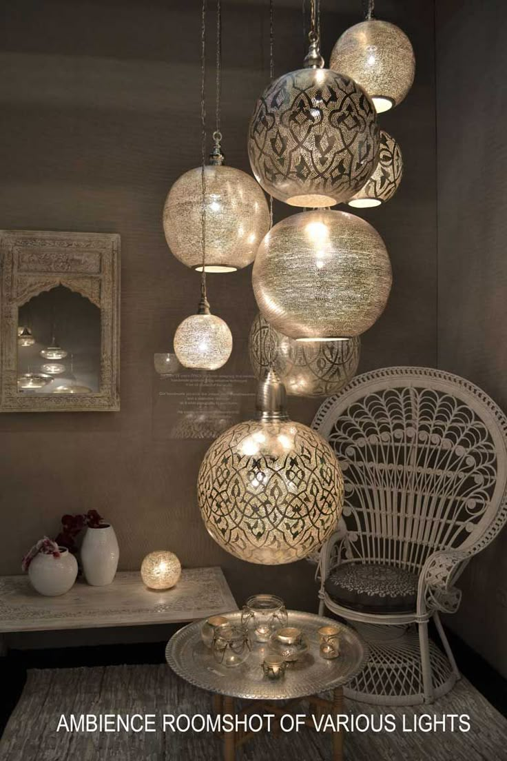 a room filled with lots of hanging lights and chairs next to a table covered in candles