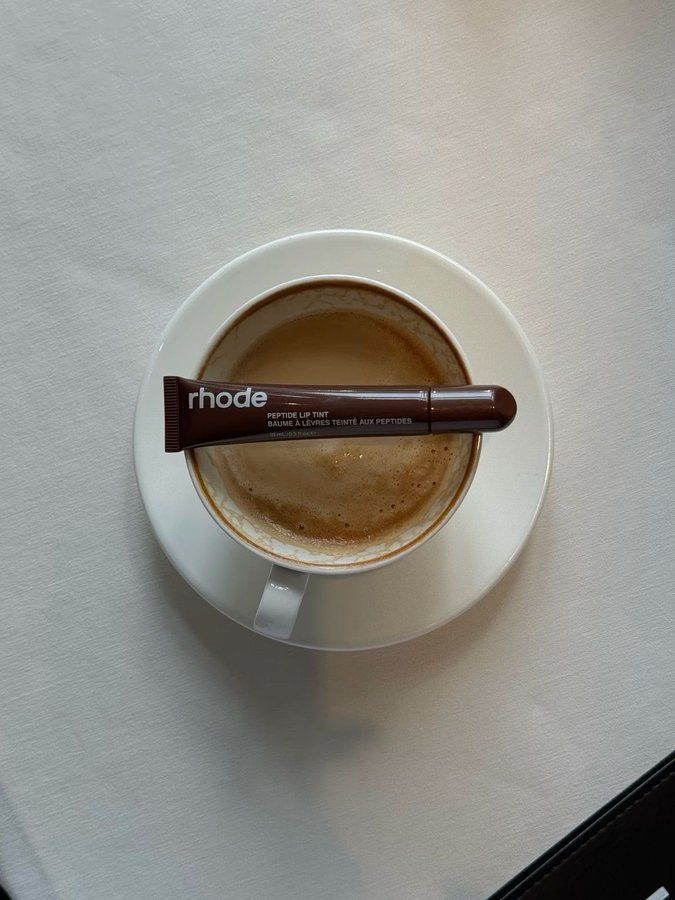 a cappuccino in a white cup with a brown stick sticking out of it