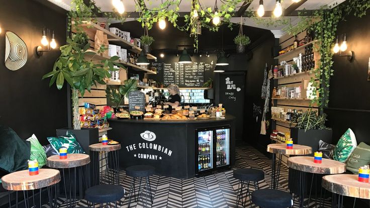 the restaurant is decorated in black and white chevrons with plants hanging from the ceiling