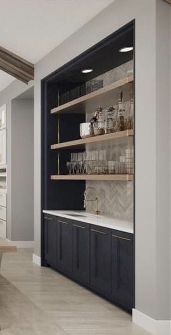 a kitchen with white cabinets and shelves filled with glassware on the counter top, next to a sink