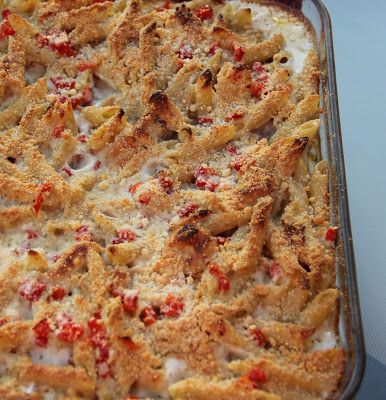 a casserole dish with meat and cheese in it sitting on a blue surface