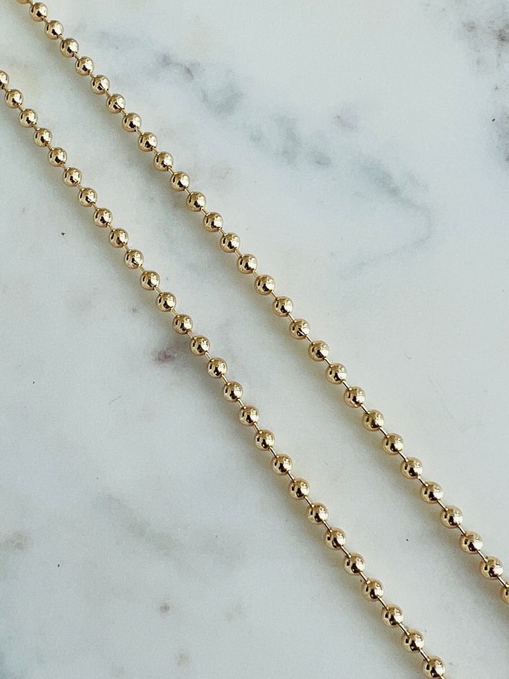 Chain Length: 20", 24" Chain Width: 3mm About Gold Filled Jewelry:What is gold-filled? We carry gold filled jewelry that is composed of a solid layer of 18kt gold, that is bonded to a base metal. Gold Filled and vermeil jewelry are great quality alternatives to solid gold. With proper care and storage, you will have jewelry that will last a lifetime. Tips to make your jewelry last:1. Keep it dry. Store your jewelry in the plastic bag included in your purchase.2. Avoid harsh chemicals such as per 14k Gold Ball Chain Necklace, Classic Gold Ball Chain Necklace, Everyday Gold Ball Chain Necklace, Gold Jewelry With Rolo Chain And Round Beads, Gold Jewelry With Rolo Chain And Beaded Details, Gold Necklace Women, Vermeil Jewelry, Gold Filled Earrings, Personalized Bracelets