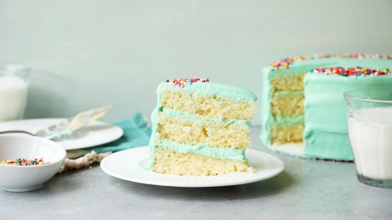 a piece of cake on a plate next to a glass of milk and some other food