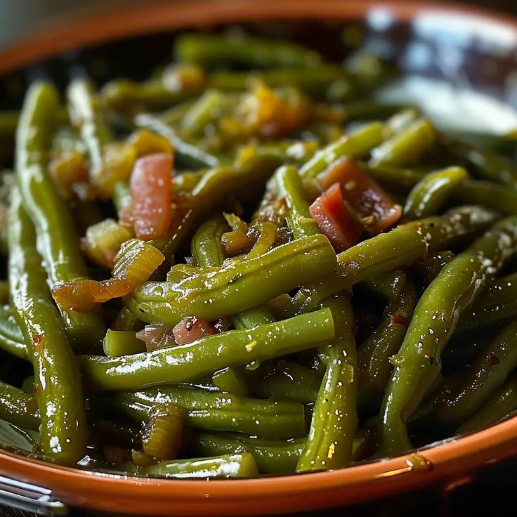 a bowl filled with green beans and bacon