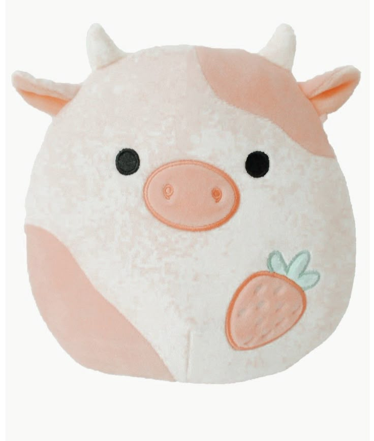 a pink pig pillow with black eyes and nose