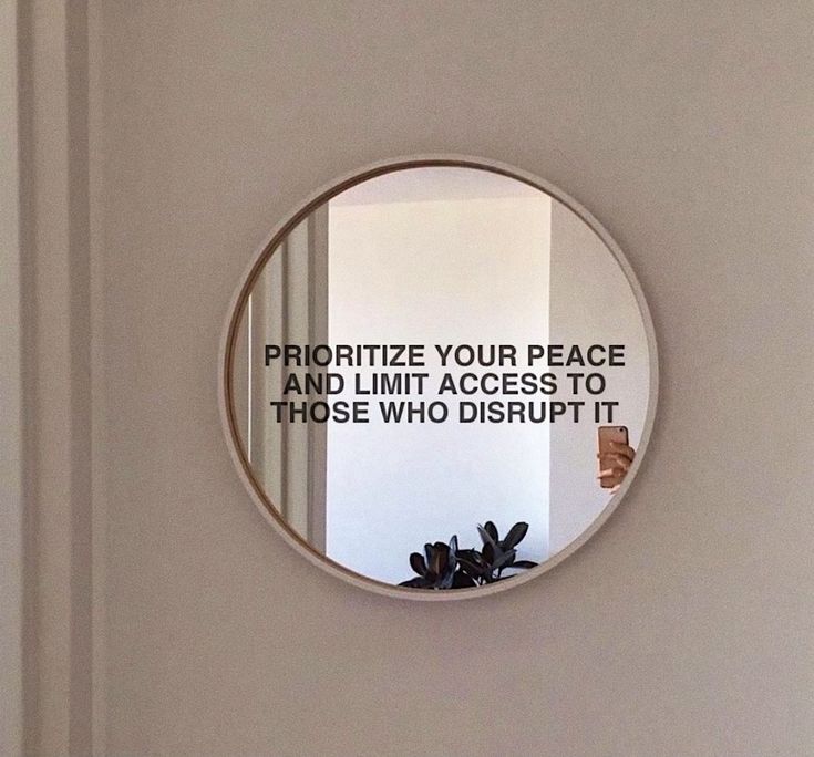 a round mirror with a quote on it in the middle of a wall above a door