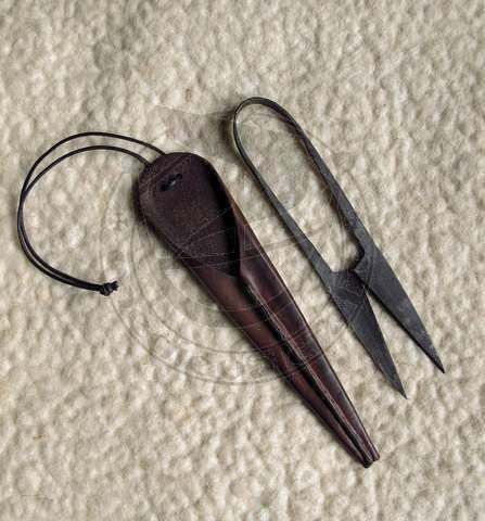 an old pair of scissors is laying on the floor next to another item that appears to have been cut off