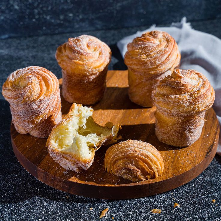 several pastries are on a wooden plate