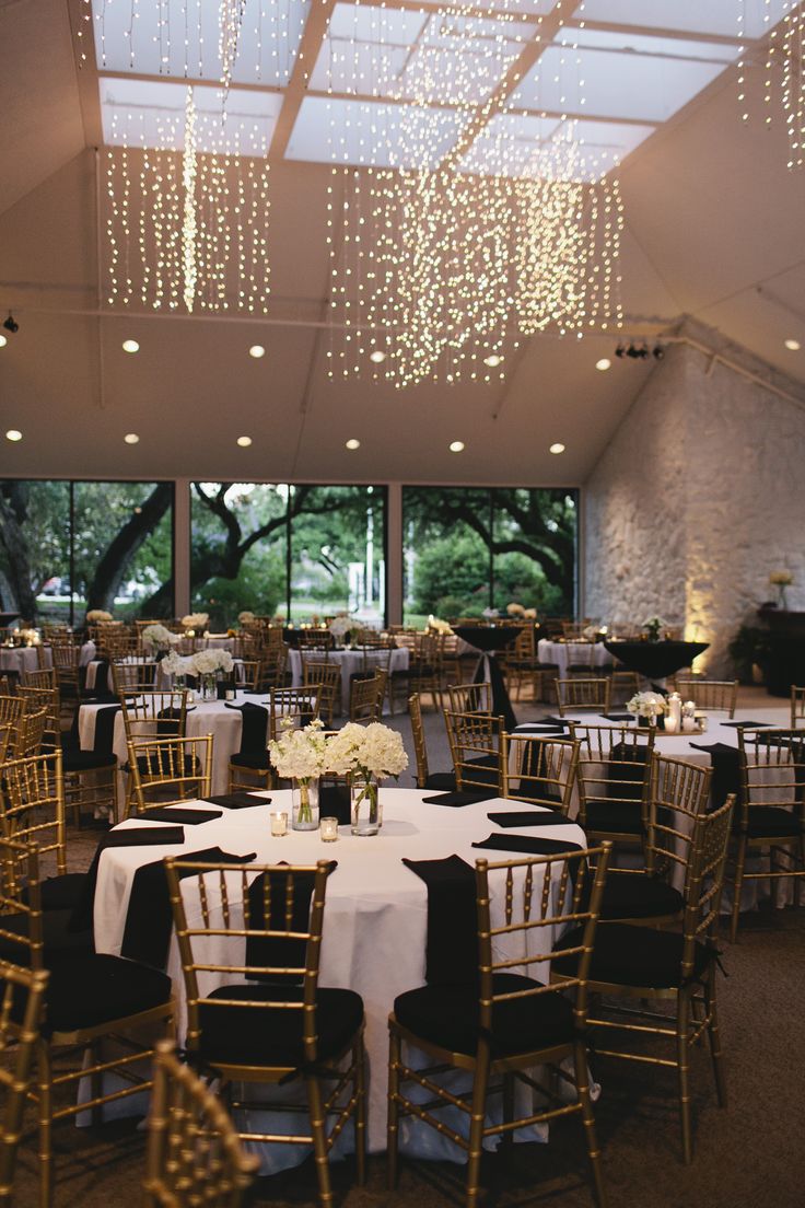 tables and chairs are set up for an event with chandeliers hanging from the ceiling