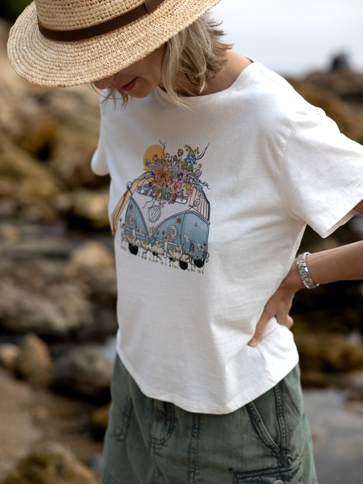 Ride the waves in style with our unique, hand-illustrated surf bus tee for women! Made from ultra-soft 100% cotton, this relaxed fit tee features vibrant floral details and is signed by the artist. Perfect gift for beach lovers and surfer girls who crave a coastal vibe. Trendy Cotton T-shirt For Surfing, Bohemian Short Sleeve Beach T-shirt, Summer Cotton T-shirt For Surfing, Summer Hippie T-shirt With Screen Print, Hippie Summer T-shirt With Screen Print, Hippie Screen Print T-shirt For Summer, Hippie Style Screen Print T-shirt For Summer, Hippie Style Summer T-shirt With Screen Print, Bohemian T-shirt For Beach With Short Sleeves