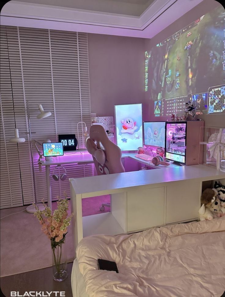 a room with several computer screens on the wall and two stuffed animals sitting on the bed