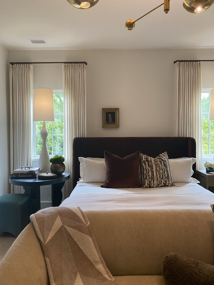 a large bed sitting in the middle of a bedroom next to two tables and lamps