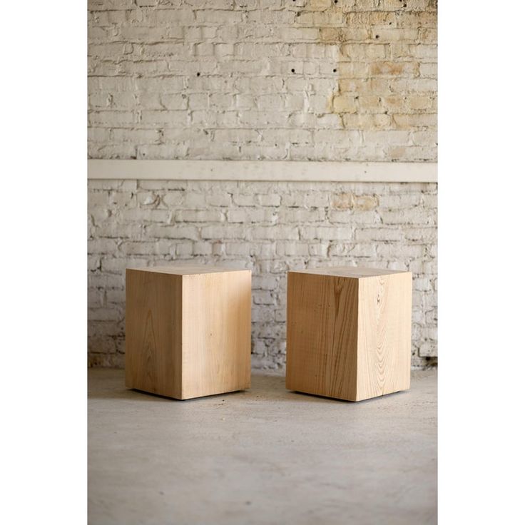 two wooden blocks sitting next to each other in front of a brick wall and floor