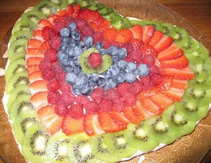 a heart shaped fruit platter with kiwis, strawberries and blueberries