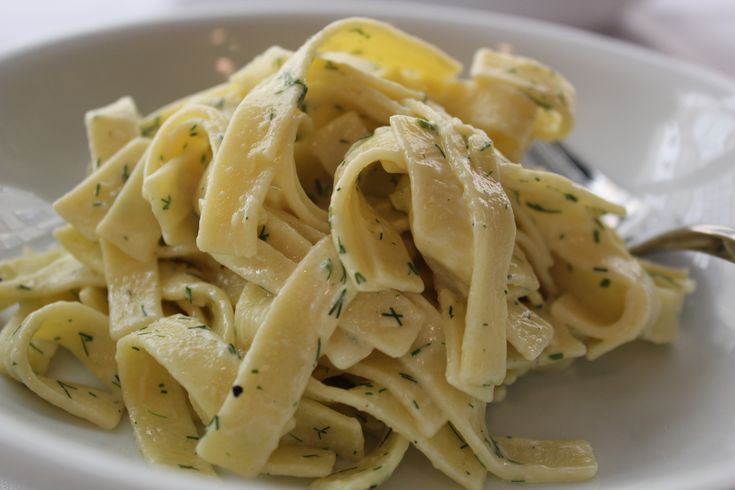 a white plate topped with pasta covered in sauce