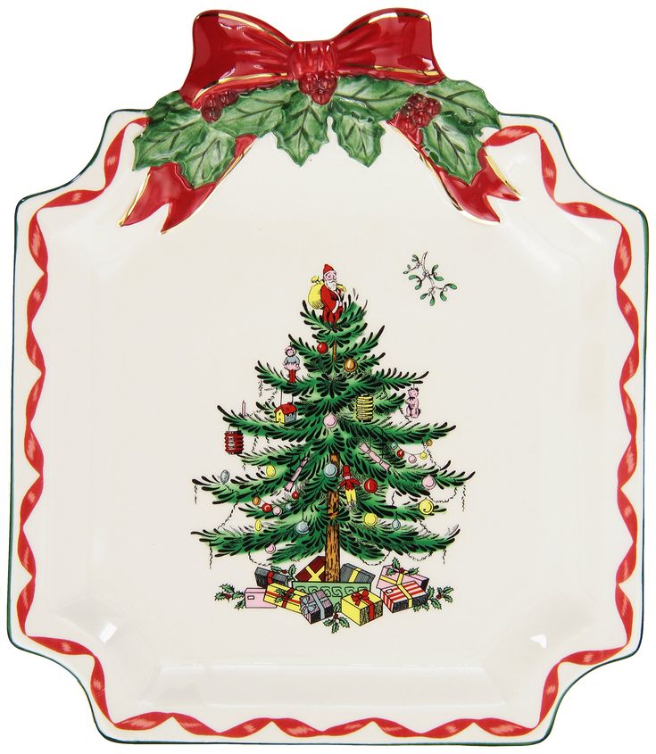 a christmas tree on a white plate with red trimmings and bows around the edge