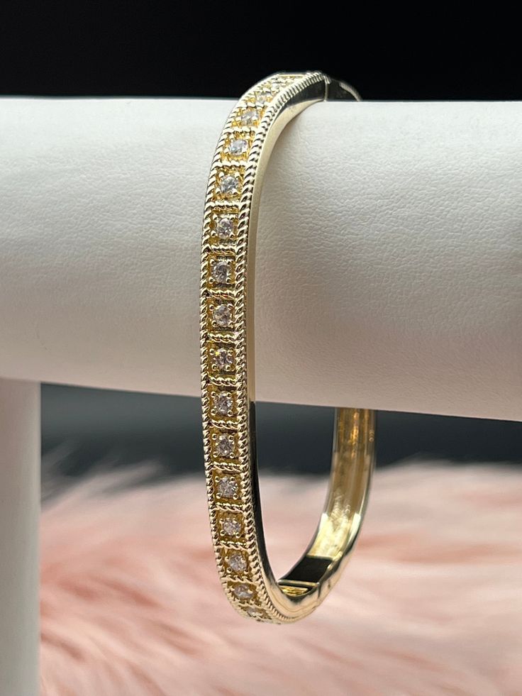 The CZ Diamond Square Bangle Bracelet is a contemporary and elegant accessory, featuring a sleek square-shaped design encrusted with dazzling cubic zirconia (CZ) diamonds. This sophisticated bracelet offers a modern twist on the classic bangle, making it a perfect blend of luxury and style. Size: 7 1/4 inches - Inner Diameter Material: Brass with 18K Gold Plating with Rhodium Coating Lead Free and Hypoallergenic Classic Cubic Zirconia Bangle Bracelet, Classic Gold Bangle Bracelet With Cubic Zirconia, Classic Cubic Zirconia Bangle With Jubilee Bracelet, Classic Bangle With Diamond Accents And Cubic Zirconia, Modern Cubic Zirconia Bracelets In Diamond White, Modern Diamond White Cubic Zirconia Bracelets, Classic Gold Cubic Zirconia Bangle Bracelet, Gold Bangle Bracelet With Diamond Cut Cubic Zirconia, Formal Cubic Zirconia Bangle Bracelet