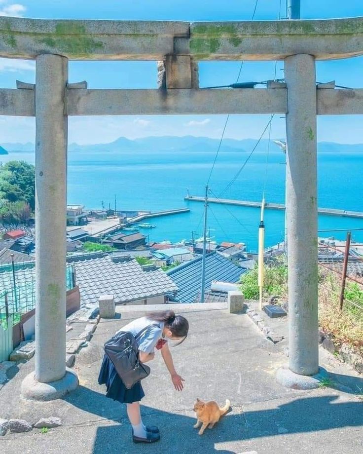 a person petting a dog in front of an overhanged area with water