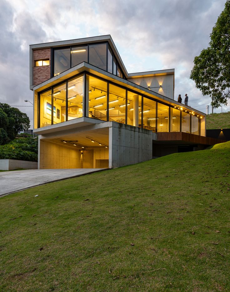 a modern house on top of a grassy hill