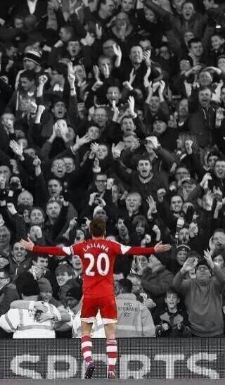 the soccer player is celebrating his goal in front of an enormous group of people with their hands up