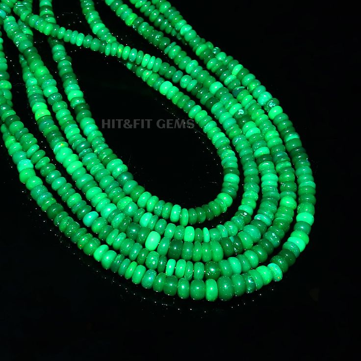 green glass beads are glowing in the dark, and there is no image to describe