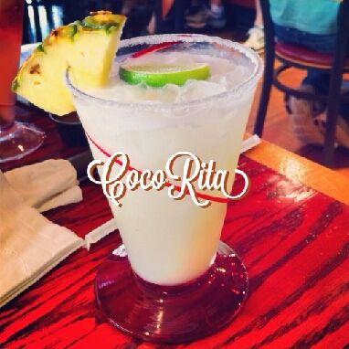 a close up of a drink on a table at a restaurant with pineapples