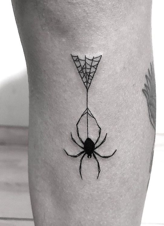 a spider web tattoo on the leg