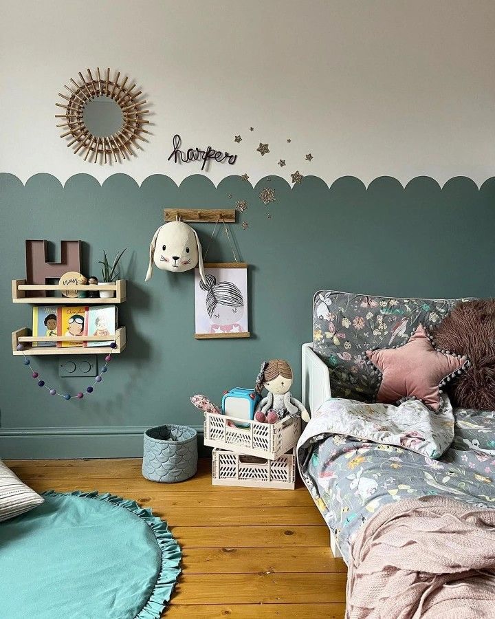 a child's bedroom with green walls and wooden floors, decorated in pastel colors