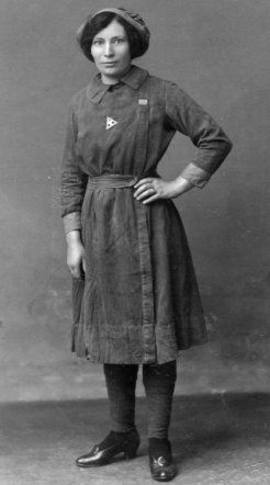 an old black and white photo of a woman wearing a dress with buttons on it