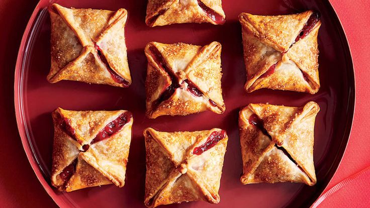 nine small pastries on a red plate, with one cut in half to show the filling