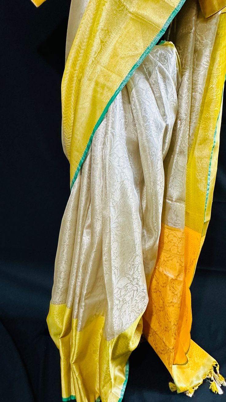 Bringing you the finest collection of Banarasi Tissue Silk Sarees yet another stylish , elegant and timeless piece from our master weavers in Banaras. Adorn this Kanchipuram inspired tissue silk saree in gold zari with floral jaal all over. With double border on the bottom and contrast color pallu this piece is gorgeous to the core and timeless . Luxurious fabric with softness and sheen just remarkable. Photos don't do justice .. this saree is just... glamorous Comes with fall/ Pico / tassels and a stitched blouse. Blouse Detail: Stitched blouse size 38, upto 42. front closure and padded with elbow level sleeves. Saree comes in a beautiful saree cotton bag. Note: Colors that show up on your screen may vary slightly from the actual product due to variations in settings. Also, the actual pro Gold Pre-draped Saree With Traditional Patterns For Festivals, Transitional Yellow Chanderi Pre-draped Saree, Yellow Tussar Silk Pre-draped Saree For Diwali, Yellow Handloom Pre-draped Saree For Wedding, Festive Yellow Tussar Silk Pre-draped Saree, Anarkali Style Cream Silk Saree, Yellow Semi-stitched Handloom Saree, Cream Tissue Silk Saree With Traditional Drape, Cream Tissue Silk Saree In Traditional Drape