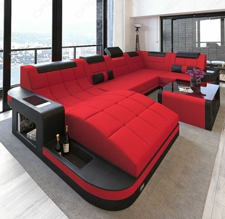 a large red couch sitting in front of a window