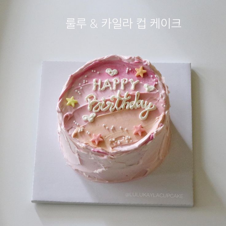 a birthday cake with pink frosting and stars on it is sitting on a white surface