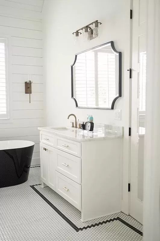 a black and white bathroom with a claw foot tub