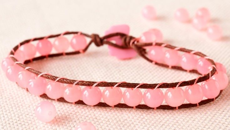 two pink bracelets sitting on top of a table