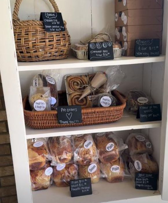 the shelves are filled with breads, pastries and other items for sale in baskets