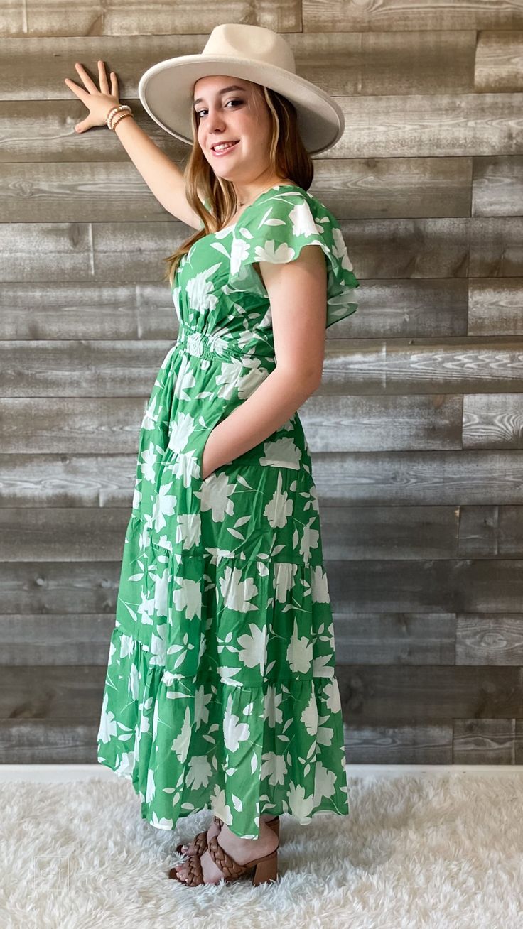 FINAL SALE this green and white floral dress from wishlist is giving me vacay vibes! perfect for a night out, sipping your favorite bev. it's also a lovely dress for a summer wedding or a bridal shower. a maxi dress with flutter sleeves, an elegant neckline, smocking at the waist and back, with a tiered skirt. it's lined and has pockets. you will look timeless in this dress. pair with some subtle jewelry and accessories and the perfect sandals to complete the look! our model is wearing a size sm Green Summer Floral Maxi Dress, Spring Green Floral Print Maxi Dress, Green Floral Maxi Summer Dress, Green Floral Maxi Dress For Summer, Green Floral Print Maxi Dress For Spring, Green Maxi Sundress For Summer, Green Maxi Length Summer Sundress, Green Floral Dress For Summer Brunch, Green Midi Floral Dress For Vacation