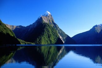 the mountains are reflected in the still water