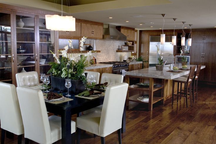 a dining room table and chairs in a kitchen with wood flooring on the walls