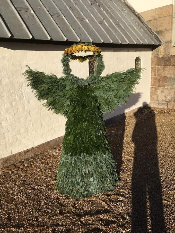 a statue made out of grass with a wreath on it's head and arms