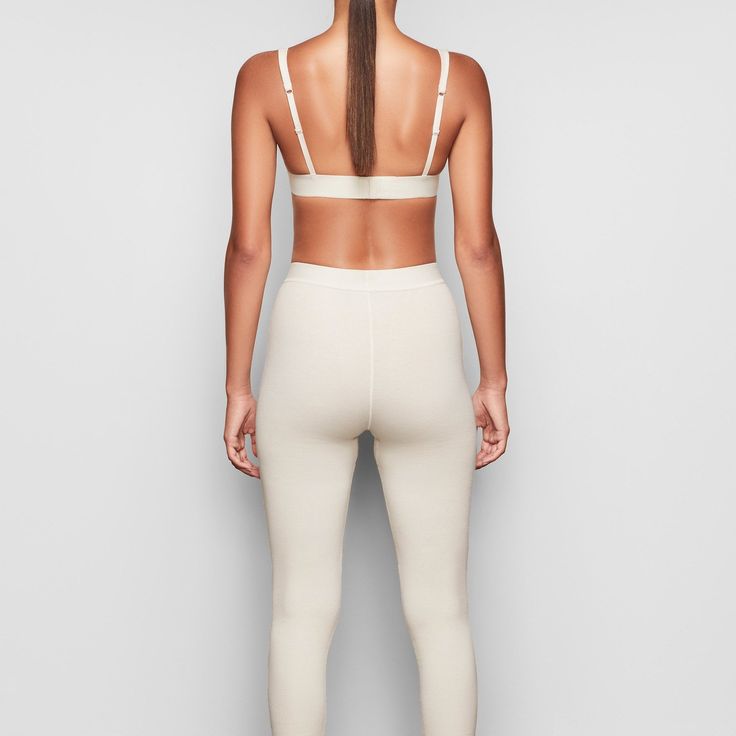 These cotton leggings hug the body yet allow your skin to breathe with cool and comfy natural fibers. The classic, rustic design elevates your lounge look. | SKIMS Legging | White | Cotton Rib Fitted Full Length Ribbed Activewear, High Stretch Ribbed Elastane Leggings, Fitted Ribbed Athleisure Leggings, Fitted Ribbed Leggings For Athleisure, Fitted Ribbed Yoga Pants, Sporty Seamless Elastane Leggings, Sporty Stretch Ribbed Pants, Tight Ribbed Leggings For Loungewear, Fitted Ribbed Tights For Loungewear