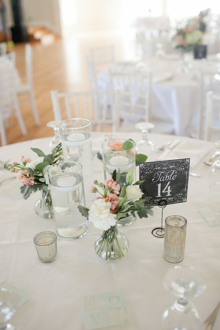 the table is set with white linens, silverware and floral centerpieces