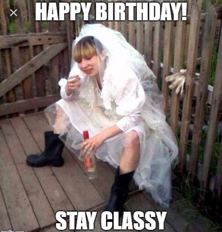 a woman in white dress sitting on wooden floor next to fence and holding a bottle