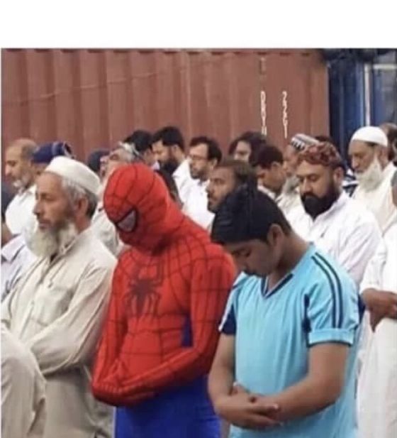 a group of men standing next to each other in front of a building with a spider man on their chest