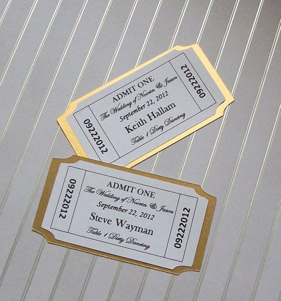 two tickets sitting next to each other on top of a white table with gold trim